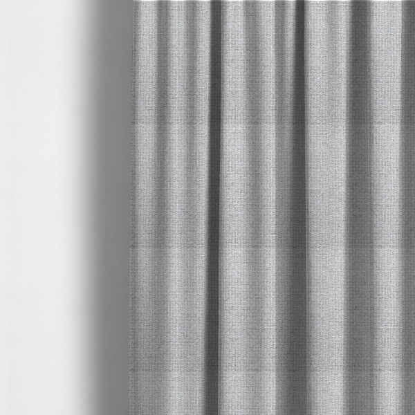 The fabric used to create these made-to-measure curtains is a fabric in a cool-toned light silver or pale grey. The weave features interlaced white and soft grey threads, creating a bright, contemporary textured finish.