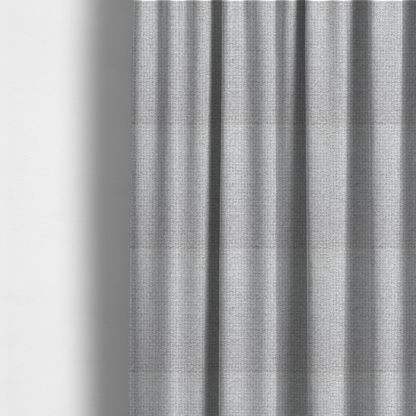 The fabric used to create these made-to-measure curtains is a fabric in a cool-toned light silver or pale grey. The weave features interlaced white and soft grey threads, creating a bright, contemporary textured finish.