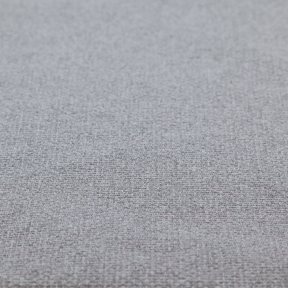 An upholstery fabric in a cool pebble grey. The interlacing of light grey and off-white threads creates a clean, contemporary basket weave pattern with a matte finish.