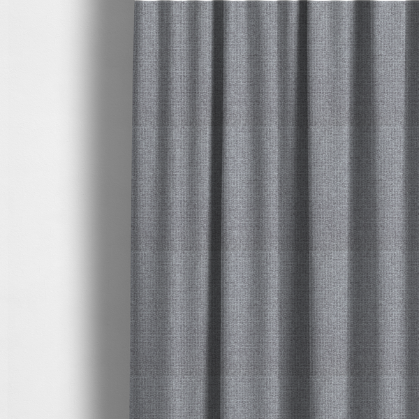The fabric used to create these made-to-measure curtains is a upholstery fabric in a cool pebble grey. The interlacing of light grey and off-white threads creates a clean, contemporary basket weave pattern with a matte finish.