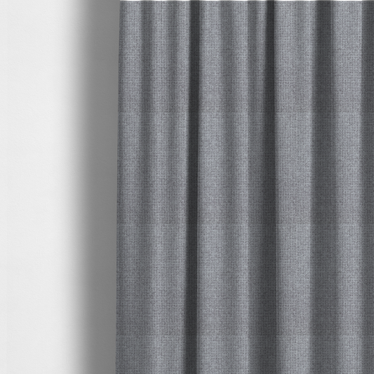 The fabric used to create these made-to-measure curtains is a upholstery fabric in a cool pebble grey. The interlacing of light grey and off-white threads creates a clean, contemporary basket weave pattern with a matte finish.