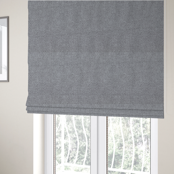 The fabric used to create these Roman blinds is a upholstery fabric in a cool pebble grey. The interlacing of light grey and off-white threads creates a clean, contemporary basket weave pattern with a matte finish.