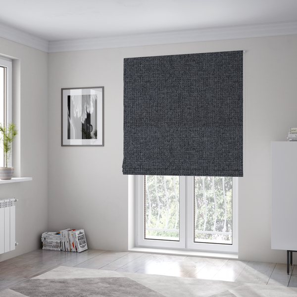 The fabric used to create these Roman blinds is a fabric in a deep charcoal or carbon grey. The high-contrast weave features heavily interlaced black and slate grey fibres for a dense, rugged texture.