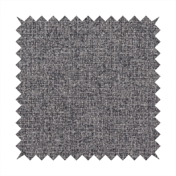 A fabric in storm grey. A balanced mid-to-dark grey weave featuring a complex interlacing of ash and soot.