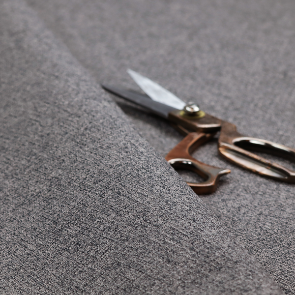 A fabric in storm grey. A balanced mid-to-dark grey weave featuring a complex interlacing of ash and soot.