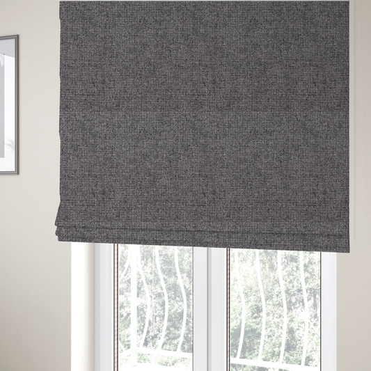 The fabric used to create these Roman blinds is a fabric in storm grey. A balanced mid-to-dark grey weave featuring a complex interlacing of ash and soot.