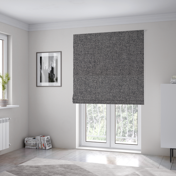The fabric used to create these Roman blinds is a fabric in storm grey. A balanced mid-to-dark grey weave featuring a complex interlacing of ash and soot.