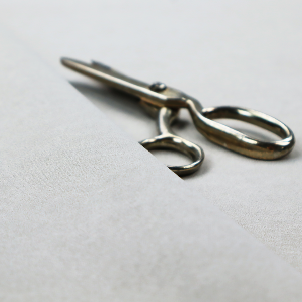 An off-white with a dense, felt-like or fibrous texture. The material features a subtle, marbled appearance created by a blend of pale grey and off-white fibres, giving it a soft, matte finish similar to weathered wool or industrial felt.