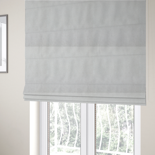 The fabric used to create these Roman blinds is a creamy off-white fabric with a dense, velvety or short-pile texture. The surface is uniform and soft, featuring a fine, grainy appearance that suggests a plush material like micro-suede or high-end upholstery velvet.