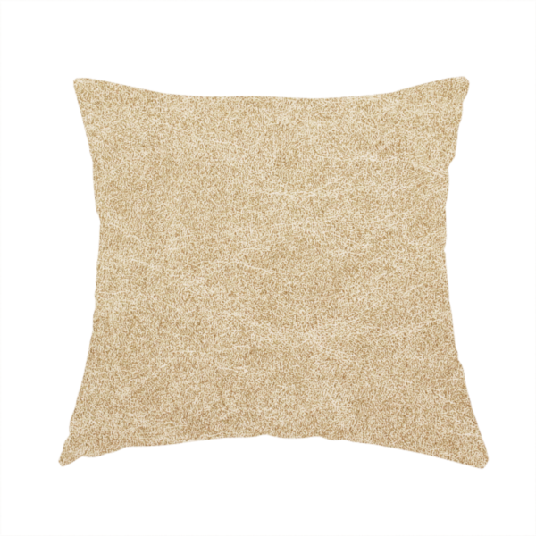 The fabric used to create these handmade cushions is a golden-tan or sand-coloured fabric with a dense, weathered texture. The material has a soft, matte finish with a fine mottled pattern of light cream and warm brown fibres. Subtle, irregular horizontal "crackle" lines or faint creases run throughout the surface, giving it the weathered appearance of distressed suede or pressed wool.