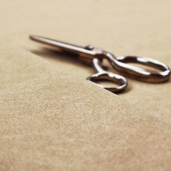 A golden-tan or sand-coloured fabric with a dense, weathered texture. The material has a soft, matte finish with a fine mottled pattern of light cream and warm brown fibres. Subtle, irregular horizontal "crackle" lines or faint creases run throughout the surface, giving it the weathered appearance of distressed suede or pressed wool.