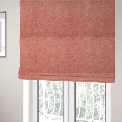 The fabric used to create these Roman blinds is a terracotta or muted coral fabric with a rich, distressed texture. The material features a fine, stippled blend of reddish-clay tones and lighter peachy fibres. It is characterized by faint, irregular light-coloured "crackle" lines that give it the appearance of weathered suede, microfiber, or industrial felt.