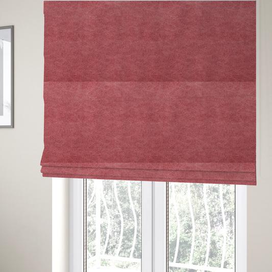 The fabric used to create these Roman blinds is a deep rose or berry-red fabric with a rich, distressed felt-like texture. The surface features a fine, stippled pattern of muted red and soft pink fibres, creating a weathered effect. Delicate, irregular light-coloured "crackle" lines run throughout, giving it an organic, weathered look similar to suede or industrial-grade wool.