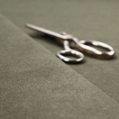 An olive-drab or sage-green fabric with a rich, distressed texture. The material features a dense, mottled pattern where dark earthy green fibres are interspersed with lighter, pale-green highlights. Like others in this series, it is characterized by faint, irregular light-coloured "crackle" lines that give it the appearance of weathered suede or industrial felt.