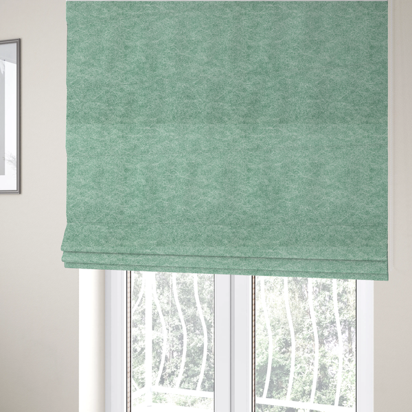 The fabric used to create these Roman blinds is a seafoam or sage green fabric with a rich, distressed felt-like texture. The material features a vibrant yet soft mottled pattern of mint green and pale cream fibres. It is characterized by the signature irregular, light-coloured "crackle" lines found in this collection, giving it the weathered appearance of premium suede or industrial wool.