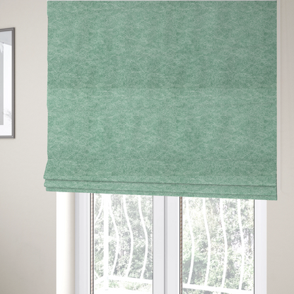 The fabric used to create these Roman blinds is a seafoam or sage green fabric with a rich, distressed felt-like texture. The material features a vibrant yet soft mottled pattern of mint green and pale cream fibres. It is characterized by the signature irregular, light-coloured "crackle" lines found in this collection, giving it the weathered appearance of premium suede or industrial wool.