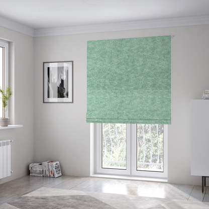 The fabric used to create these Roman blinds is a seafoam or sage green fabric with a rich, distressed felt-like texture. The material features a vibrant yet soft mottled pattern of mint green and pale cream fibres. It is characterized by the signature irregular, light-coloured "crackle" lines found in this collection, giving it the weathered appearance of premium suede or industrial wool.