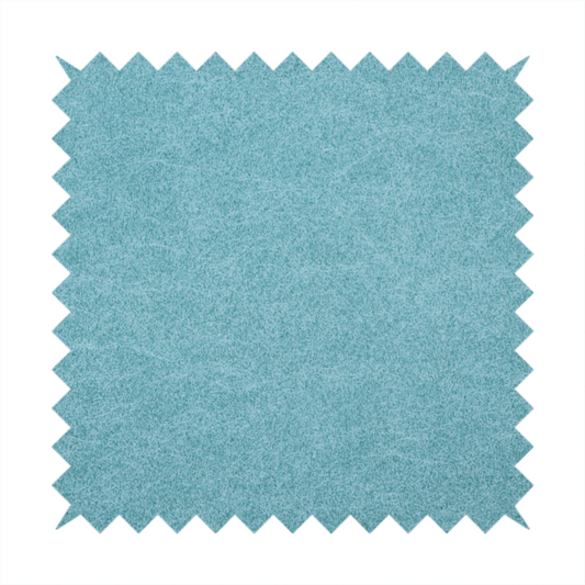 A bright aqua or turquoise fabric with a dense, distressed felt-like texture. The surface features a vibrant mottled pattern of cyan and pale blue fibres, creating a weathered effect. It is characterized by irregular, light-coloured "crackle" lines that give it the weathered appearance of premium suede or industrial wool.
