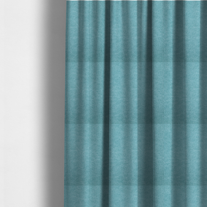 The fabric used to create these made-to-measure curtains is a bright aqua or turquoise fabric with a dense, distressed felt-like texture. The surface features a vibrant mottled pattern of cyan and pale blue fibres, creating a weathered effect. It is characterized by irregular, light-coloured "crackle" lines that give it the weathered appearance of premium suede or industrial wool.