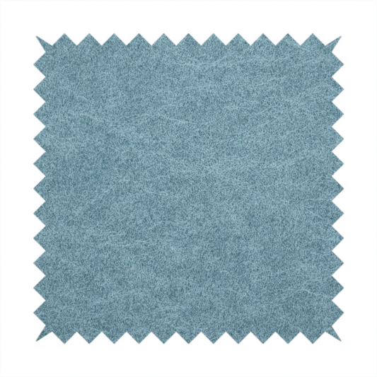 a dusty blue or slate blue fabric with a dense, distressed felt-like texture. The material features a sophisticated mottled pattern of medium blue and muted grey fibres. It contains the signature irregular, light-coloured "crackle" veins characteristic of this collection, giving it the weathered appearance of premium distressed suede or industrial wool.