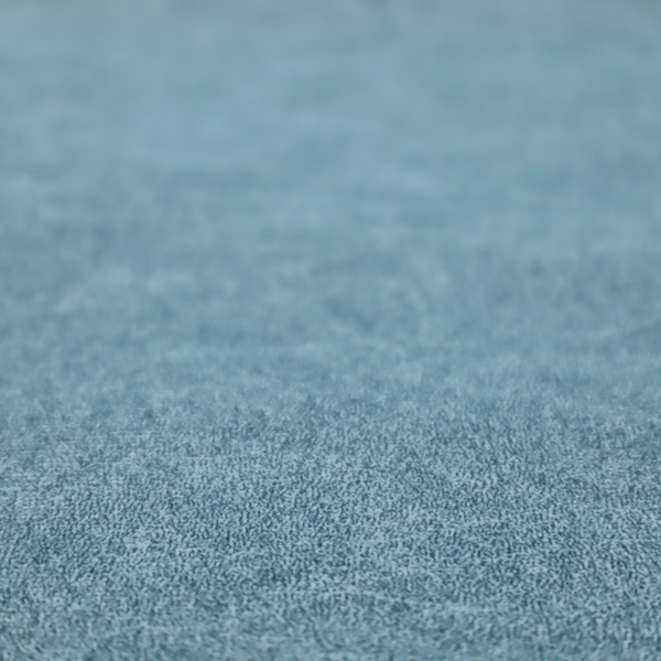 a dusty blue or slate blue fabric with a dense, distressed felt-like texture. The material features a sophisticated mottled pattern of medium blue and muted grey fibres. It contains the signature irregular, light-coloured "crackle" veins characteristic of this collection, giving it the weathered appearance of premium distressed suede or industrial wool.