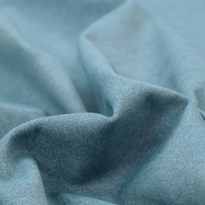 a dusty blue or slate blue fabric with a dense, distressed felt-like texture. The material features a sophisticated mottled pattern of medium blue and muted grey fibres. It contains the signature irregular, light-coloured "crackle" veins characteristic of this collection, giving it the weathered appearance of premium distressed suede or industrial wool.