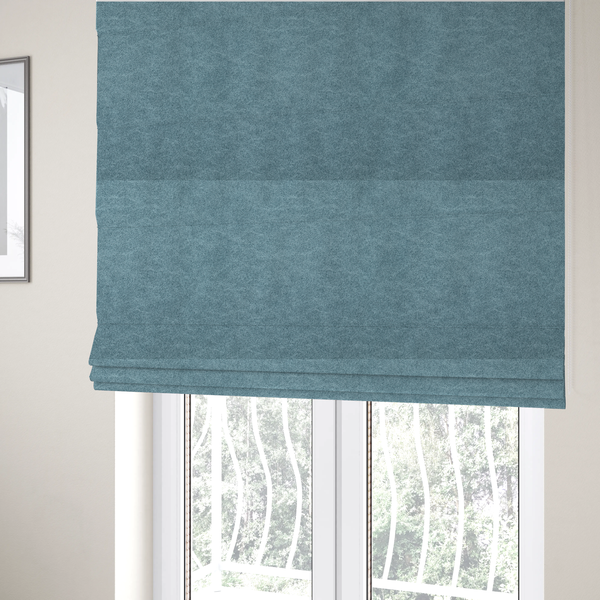 The fabric used to create these Roman blinds is a  dusty blue or slate blue fabric with a dense, distressed felt-like texture. The material features a sophisticated mottled pattern of medium blue and muted grey fibres. It contains the signature irregular, light-coloured "crackle" veins characteristic of this collection, giving it the weathered appearance of premium distressed suede or industrial wool.