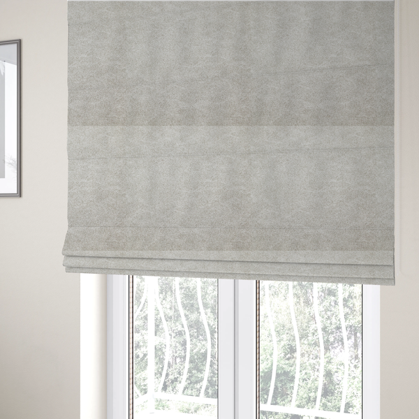 The fabric used to create these Roman blinds is a  pale greige or parchment-coloured fabric with a dense, distressed felt-like texture. The surface features a subtle mottled pattern of light cream and soft grey fibres, creating a clean, weathered look. Like the others in this collection, it includes irregular, light-coloured "crackle" lines that give it the weathered appearance of distressed suede or pressed wool.