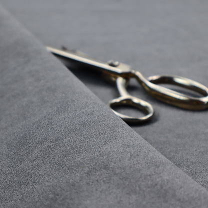 A charcoal or slate grey fabric with a rich, distressed felt-like texture. The surface features an intricate, stippled pattern of deep grey fibres mixed with lighter silver highlights. It is characterized by organic, vein-like distressing and light-coloured crackle lines, mimicking the look of weathered leather or heavy-duty industrial felt.