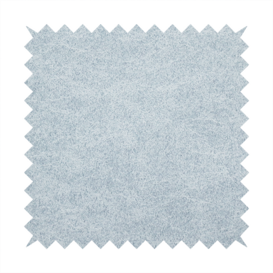 A light sky blue or powder blue fabric with a dense, distressed felt-like texture. The surface features a soft, mottled blend of pale blue and white fibres, creating a subtle weathered effect. It includes the signature irregular, light-coloured "crackle" lines seen throughout this collection, giving it the appearance of weathered microfiber or industrial wool.