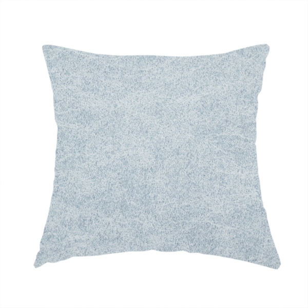 The fabric used to create this handmade cushion is a light sky blue or powder blue fabric with a dense, distressed felt-like texture. The surface features a soft, mottled blend of pale blue and white fibres, creating a subtle weathered effect. It includes the signature irregular, light-coloured "crackle" lines seen throughout this collection, giving it the appearance of weathered microfiber or industrial wool.