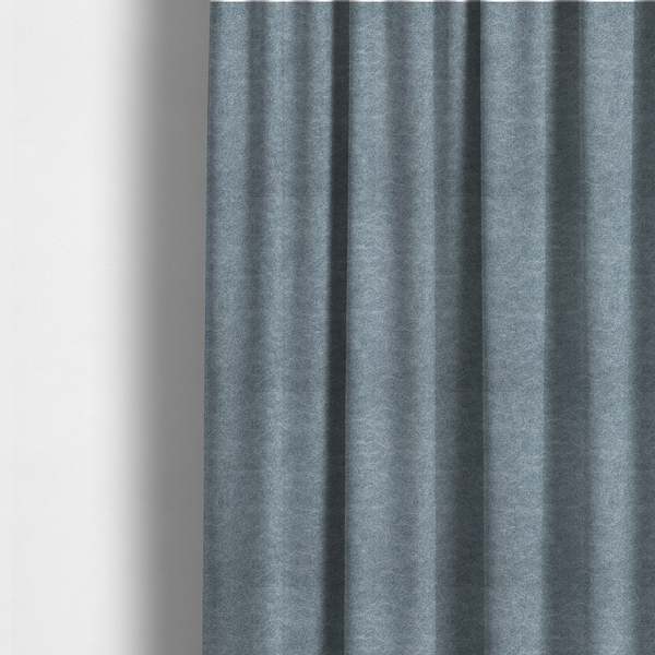 The fabric used to create these made-to-measure curtains is a steel blue or denim grey fabric with a dense, distressed felt-like texture. The material features a sophisticated mottled blend of medium blue and grey fibres, creating a cool-toned weathered effect. It includes the collection’s signature irregular, light-coloured "crackle" lines that give it the weathered appearance of premium distressed suede or industrial wool.