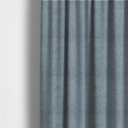 The fabric used to create these made-to-measure curtains is a steel blue or denim grey fabric with a dense, distressed felt-like texture. The material features a sophisticated mottled blend of medium blue and grey fibres, creating a cool-toned weathered effect. It includes the collection’s signature irregular, light-coloured "crackle" lines that give it the weathered appearance of premium distressed suede or industrial wool.