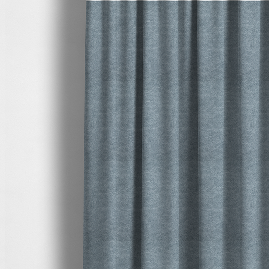 The fabric used to create these made-to-measure curtains is a steel blue or denim grey fabric with a dense, distressed felt-like texture. The material features a sophisticated mottled blend of medium blue and grey fibres, creating a cool-toned weathered effect. It includes the collection’s signature irregular, light-coloured "crackle" lines that give it the weathered appearance of premium distressed suede or industrial wool.