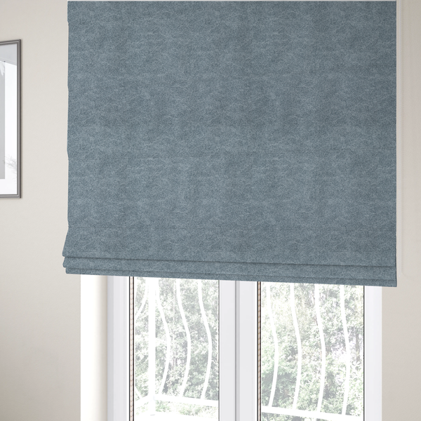 The fabric used to create these Roman blinds is a steel blue or denim grey fabric with a dense, distressed felt-like texture. The material features a sophisticated mottled blend of medium blue and grey fibres, creating a cool-toned weathered effect. It includes the collection’s signature irregular, light-coloured "crackle" lines that give it the weathered appearance of premium distressed suede or industrial wool.