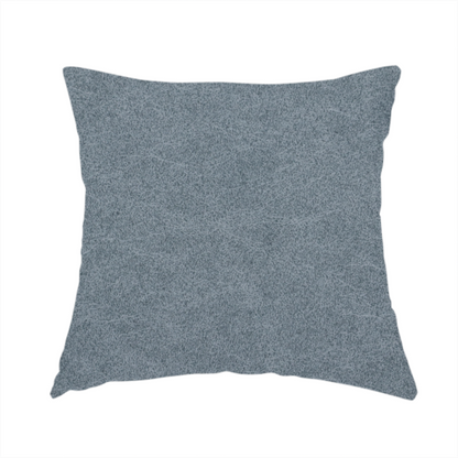 The fabric used to create these handmade cushions is a denim or dusty blue fabric with a dense, distressed felt-like texture. The surface features an intricate mottled blend of slate blue and muted grey fibres. Like the others in this collection, it is defined by organic, light-coloured "crackle" lines and a stippled appearance that mimics the look of weathered suede or high-end industrial wool.