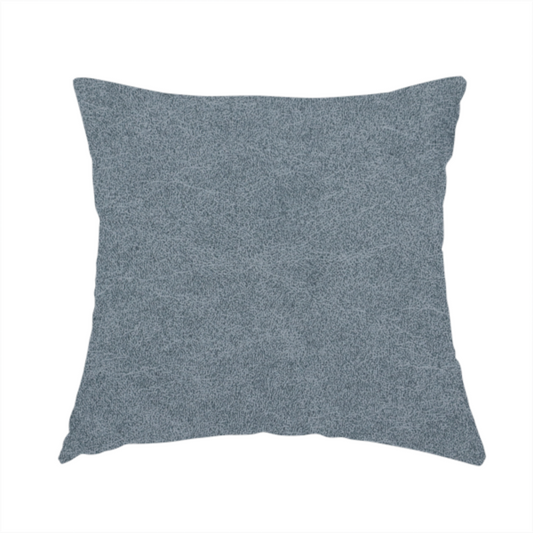 The fabric used to create these handmade cushions is a denim or dusty blue fabric with a dense, distressed felt-like texture. The surface features an intricate mottled blend of slate blue and muted grey fibres. Like the others in this collection, it is defined by organic, light-coloured "crackle" lines and a stippled appearance that mimics the look of weathered suede or high-end industrial wool.