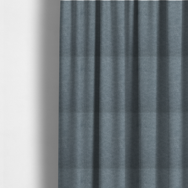 The fabric used to create these made-to-measure curtains is a denim or dusty blue fabric with a dense, distressed felt-like texture. The surface features an intricate mottled blend of slate blue and muted grey fibres. Like the others in this collection, it is defined by organic, light-coloured "crackle" lines and a stippled appearance that mimics the look of weathered suede or high-end industrial wool.
