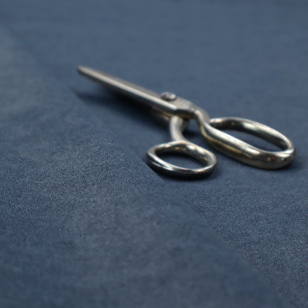 A dark slate or indigo blue fabric with a dense, distressed felt-like texture. As the deepest blue in this collection, the surface features a rich mottled blend of midnight blue and dark grey fibres. It is characterized by organic, light-coloured "crackle" lines that provide a weathered, vintage look similar to distressed leather or premium industrial wool.