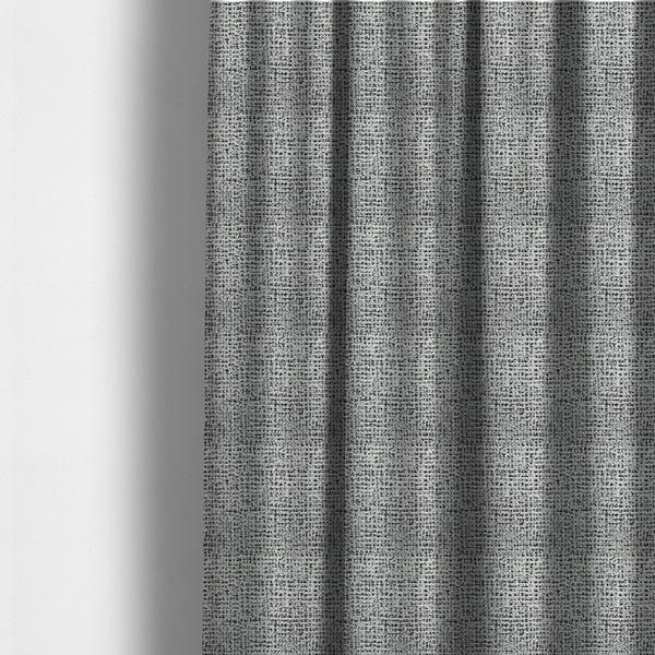 The fabric used to create these made-to-measure curtains is a dense textile with a complex, gridded texture. The fabric is composed of thick white and black yarns interwoven to create a "static" or pixelated marl effect. The weave is highly tactile, showing visible loops, knots, and characteristic of bouclé or tweed. While the overall appearance is monochromatic grey from a distance, the close-up reveals distinct, irregular blocks of stark white and deep black thread.
