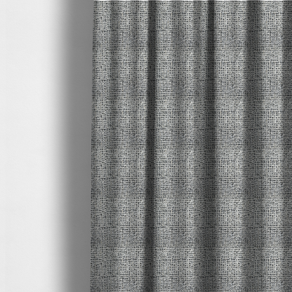 The fabric used to create these made-to-measure curtains is a dense textile with a complex, gridded texture. The fabric is composed of thick white and black yarns interwoven to create a "static" or pixelated marl effect. The weave is highly tactile, showing visible loops, knots, and characteristic of bouclé or tweed. While the overall appearance is monochromatic grey from a distance, the close-up reveals distinct, irregular blocks of stark white and deep black thread.
