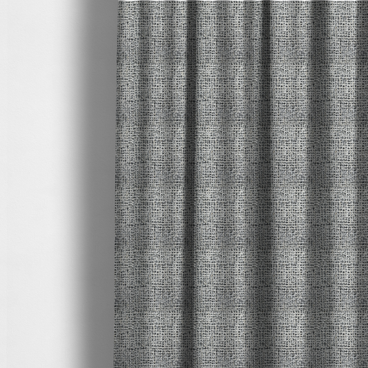 The fabric used to create these made-to-measure curtains is a dense textile with a complex, gridded texture. The fabric is composed of thick white and black yarns interwoven to create a "static" or pixelated marl effect. The weave is highly tactile, showing visible loops, knots, and characteristic of bouclé or tweed. While the overall appearance is monochromatic grey from a distance, the close-up reveals distinct, irregular blocks of stark white and deep black thread.