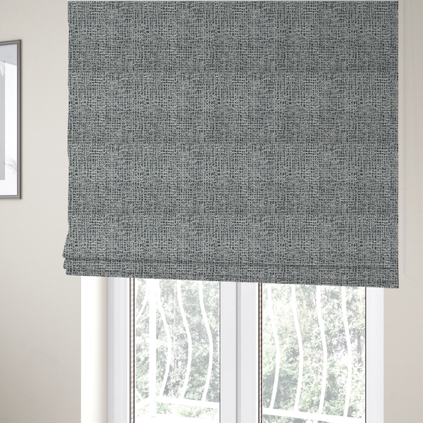 The fabric used to create these Roman blinds is a dense, multi-tonal grey woven fabric. The textile features a salt-and-pepper blend of charcoal, silver-grey, and off-white yarns in a tactile, nubby bouclé weave.