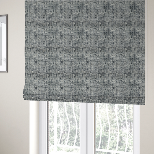 The fabric used to create these Roman blinds is a dense, multi-tonal grey woven fabric. The textile features a salt-and-pepper blend of charcoal, silver-grey, and off-white yarns in a tactile, nubby bouclé weave.