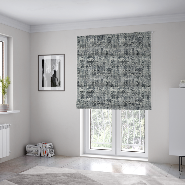 The fabric used to create these Roman blinds is a dense, multi-tonal grey woven fabric. The textile features a salt-and-pepper blend of charcoal, silver-grey, and off-white yarns in a tactile, nubby bouclé weave.