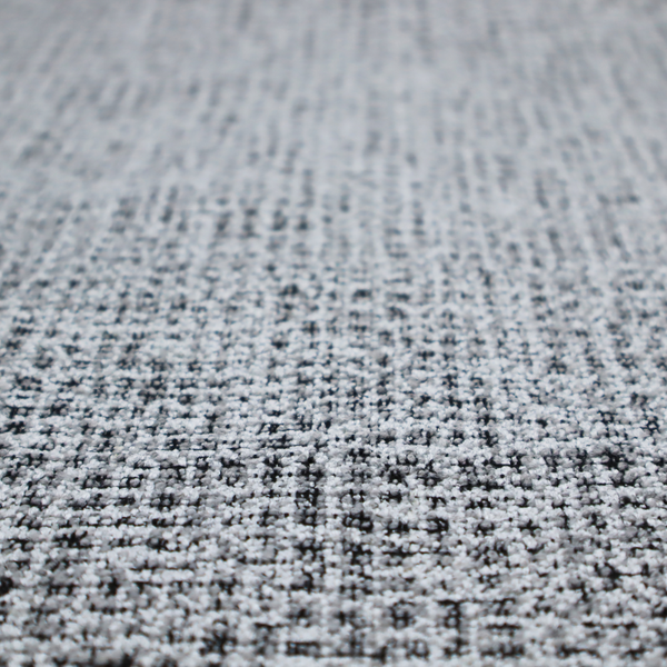 A textured woven upholstery fabric in a cool-toned grey and white salt-and-pepper pattern. The bouclé-style weave features horizontal rhythmic variations of charcoal and light grey yarns.