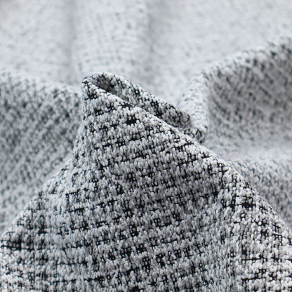 A textured woven upholstery fabric in a cool-toned grey and white salt-and-pepper pattern. The bouclé-style weave features horizontal rhythmic variations of charcoal and light grey yarns.