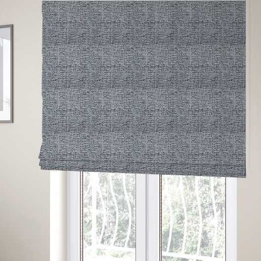 The fabric used to create these Roman blinds is a textured woven upholstery fabric in a cool-toned grey and white salt-and-pepper pattern. The bouclé-style weave features horizontal rhythmic variations of charcoal and light grey yarns.