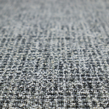 A dense, textured woven fabric in a charcoal and ash-grey salt-and-pepper pattern. The weave features tightly packed, nubby bouclé yarns with a subtle vertical and horizontal grid-like structure.