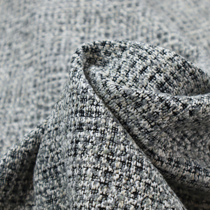 A dense, textured woven fabric in a charcoal and ash-grey salt-and-pepper pattern. The weave features tightly packed, nubby bouclé yarns with a subtle vertical and horizontal grid-like structure.